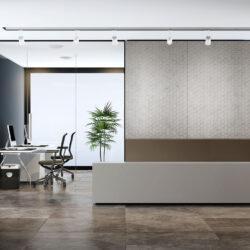 Grau strukturierte Wandpaneele hinter Rezeption mit geometrischem Wabendekor im Samt-Look