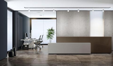 Gray textured wall panels behind reception with geometric honeycomb decor in velvet look