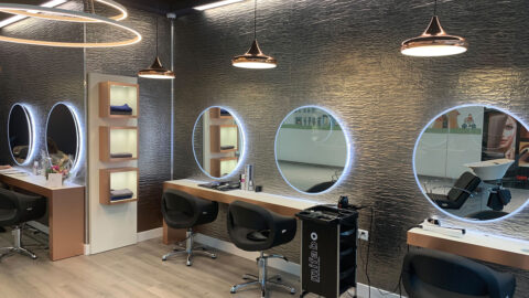 Moderner Frisiersalon mit strukturierten grauen Wandpaneelen