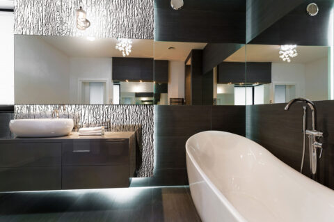 Bathroom with mirrored structure panel behind the washbasin