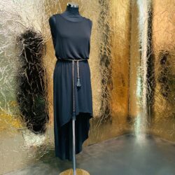 Schaufensterpuppe vor goldener, spiegelnder Designplatte mit ausgeprägte Struktur