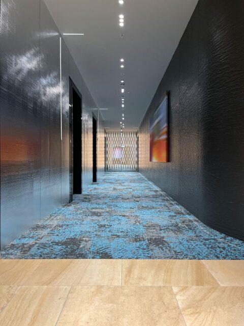 Silber reflektierende Wandpaneele im Hotelflur mit ausgeprägter Struktur in Sägerau-Optik