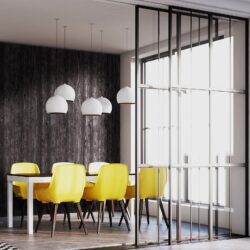 Stylishes Esszimmer mit gelben Sessel und einer schwarzen fugenlosen Wandverkleidung in verkohlter Holzoptik