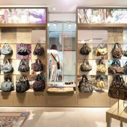 Bag store with shelves in beige and different color mirror elements