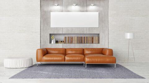 Modernes Wohnzimmer mit heller Wandverkleidung im Betonlook und braunem Ledersofa