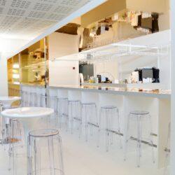 Bar in white with golden elements and transparent bar stools