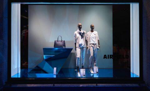 Modern shopwindow in blue colors with two mannequins in bright clothes