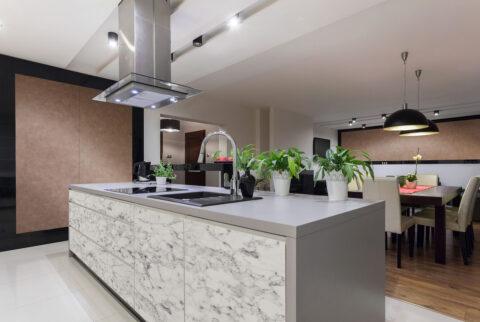 Kitchen with fronts in white, marble and gray decor, the back wall is bronze color