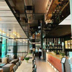 Modern industrial style restaurant with dark gray mirror elements and gray leather seating