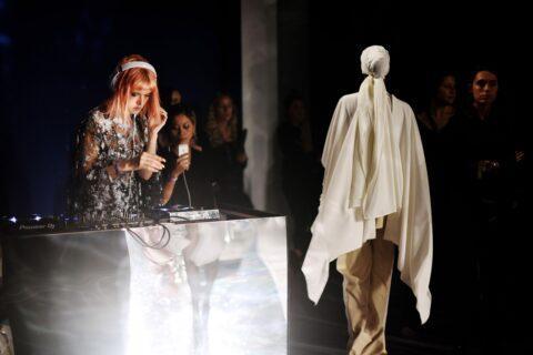 Spiegelndes DJ Pult, davor laufen Models am Laufsteg