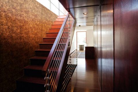 Freestanding staircase next to a wall with golden, patterned design