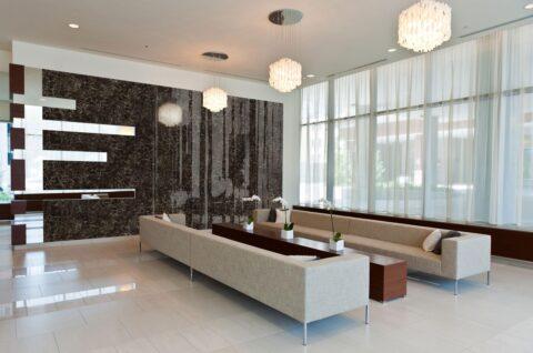 Hotel foyer with black-brown high-gloss marble-look wall paneling, seating in front of it