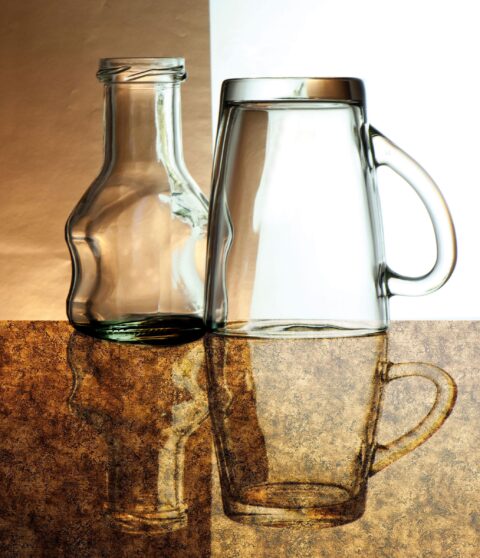 Hochglänzende Tischplatte im kupferfarbenem Vintage-Look, darauf 2 Gläser