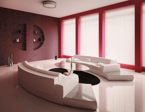 Modern living room with beige leather sofa and velvet look wine red wall