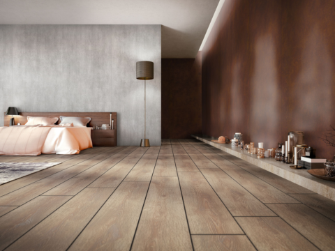 Bedroom with dark wooden floor and a wall with panels in reddish wood look