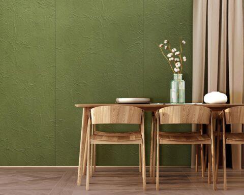 Esstisch und Stühle aus Holz, vor einer grünen, strukturierten Samtwand im Knitterlook