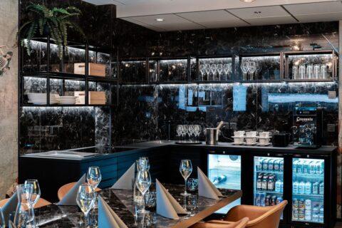 Wall cladding of a bar in high-gloss black marble look