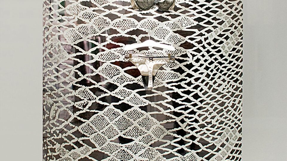 Hanging decor sheet with snake pattern print in a shop window, in front of it hangs a silver bikini