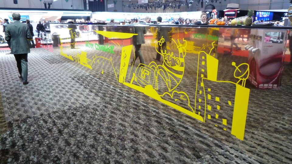 Silver bar with yellow print, in the background various exhibition stands