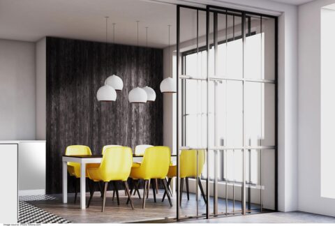 Esszimmerbereich eines Lofts, im Hintergrund eine Wandverkleidung aus verbranntem Holz