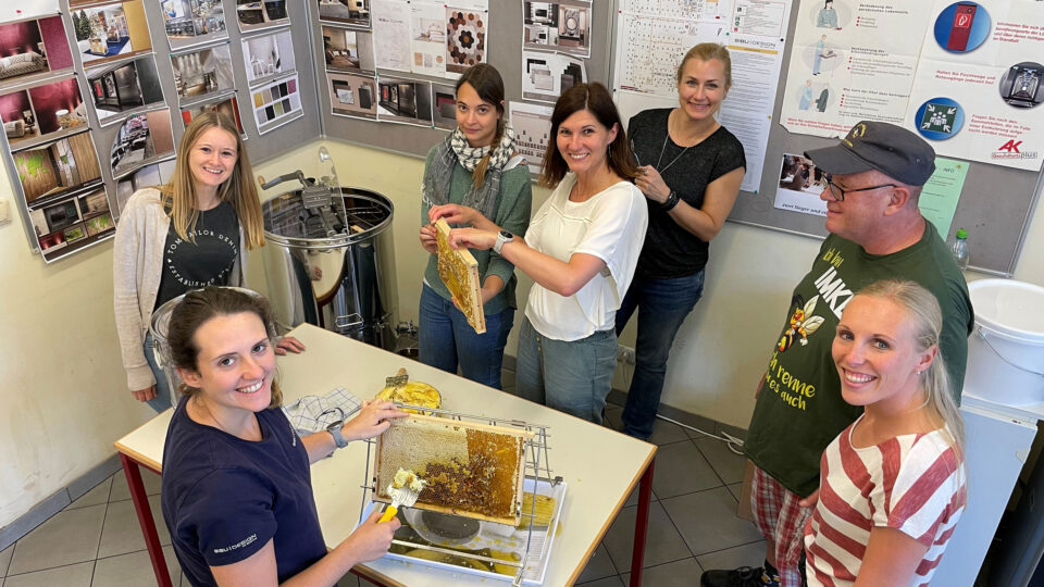 Employees removing the wax layer from the combs