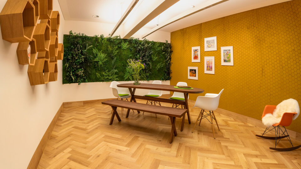 Dining area with textured curry coloured textile walls