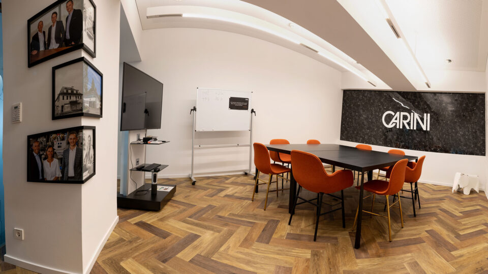 Bright meeting room with orange chairs and black table