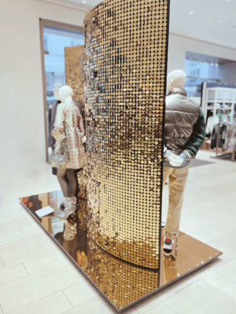 Schaufenster mit vielen Ketten aus Goldpaletten als Rückwand