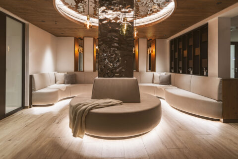 Ruheraum in Beige mit Sofa um eine Spiegelsäule und Spiegelornamenten an der Decke