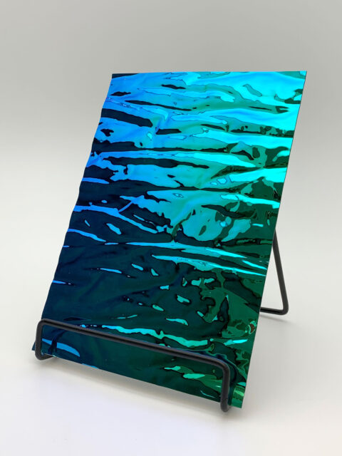 Detailaufnahme in der Größe A5 eines glänzenden, blaugrünen Dekors mit Struktur