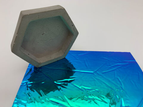 Close-up of a glossy, blue / green decor with texture and honeycomb