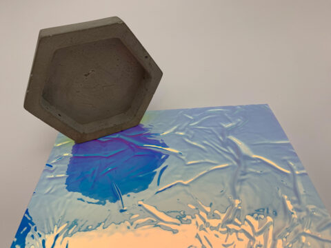 Detailaufnahme eines strukturierten glänzenden, rosablauen Dekors mit Wabe