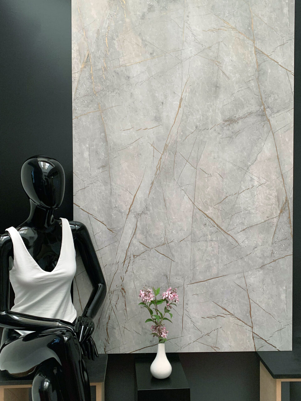 schwarze Schaufensterpuppe vor grauem Hintergrund