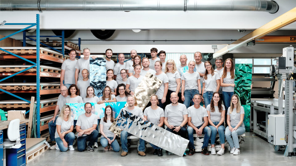 Employee group photo with the production hall in the background