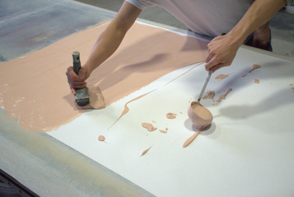 Mit Pinsel und Schöpfer wird die Farbe auf die Grundelemente des Wandbelages aufgetragen