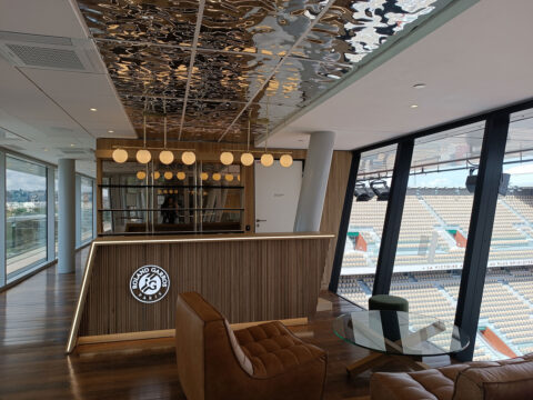 Cosy bar area with undulating mirrored ceiling with frontal view of the bar