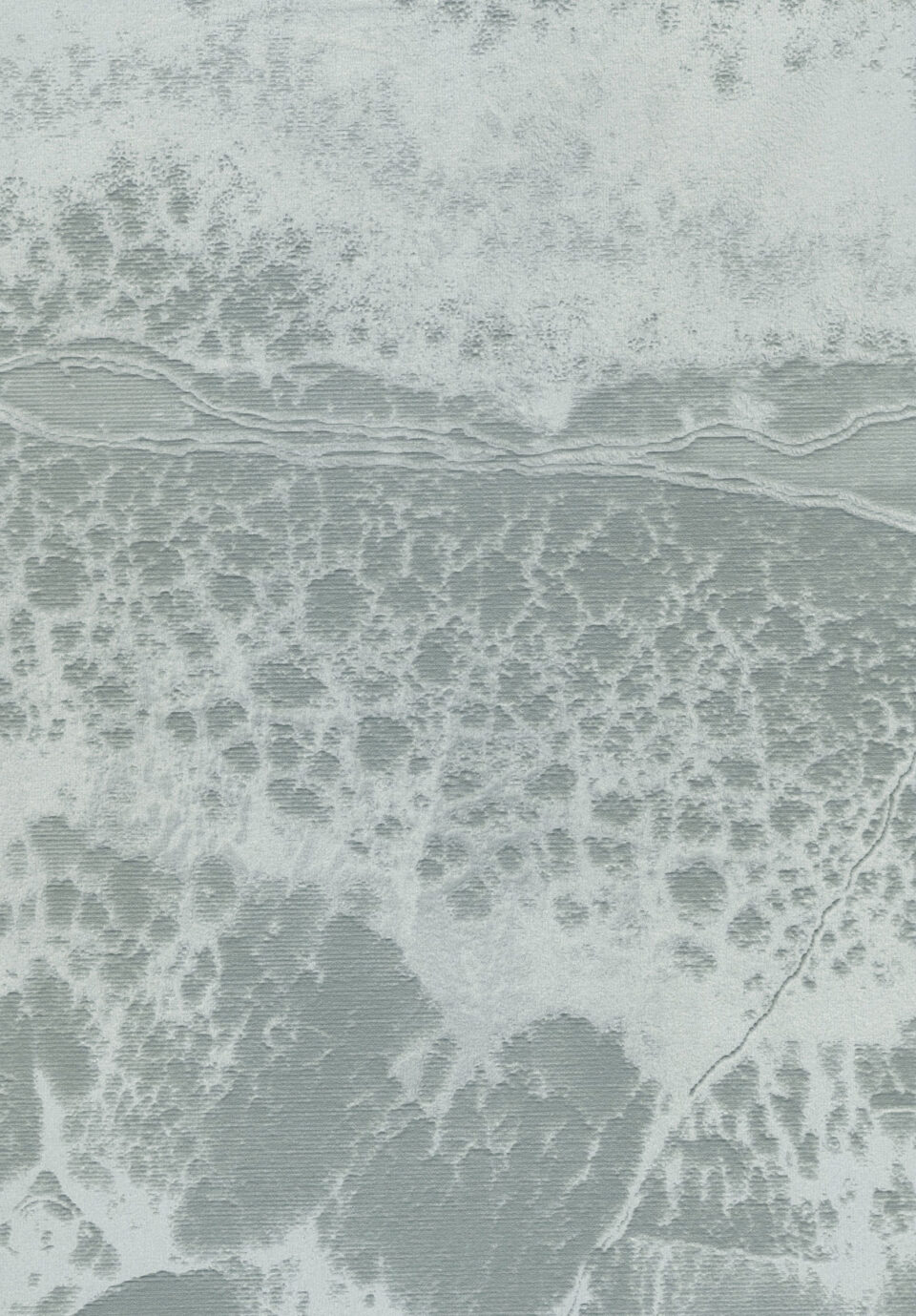Nahaufnahme einer Tapete in weiß und grau. Die Optik erinnert an einen grauen Sandstrand auf dem das Schäumen der Wellen zu sehen ist.