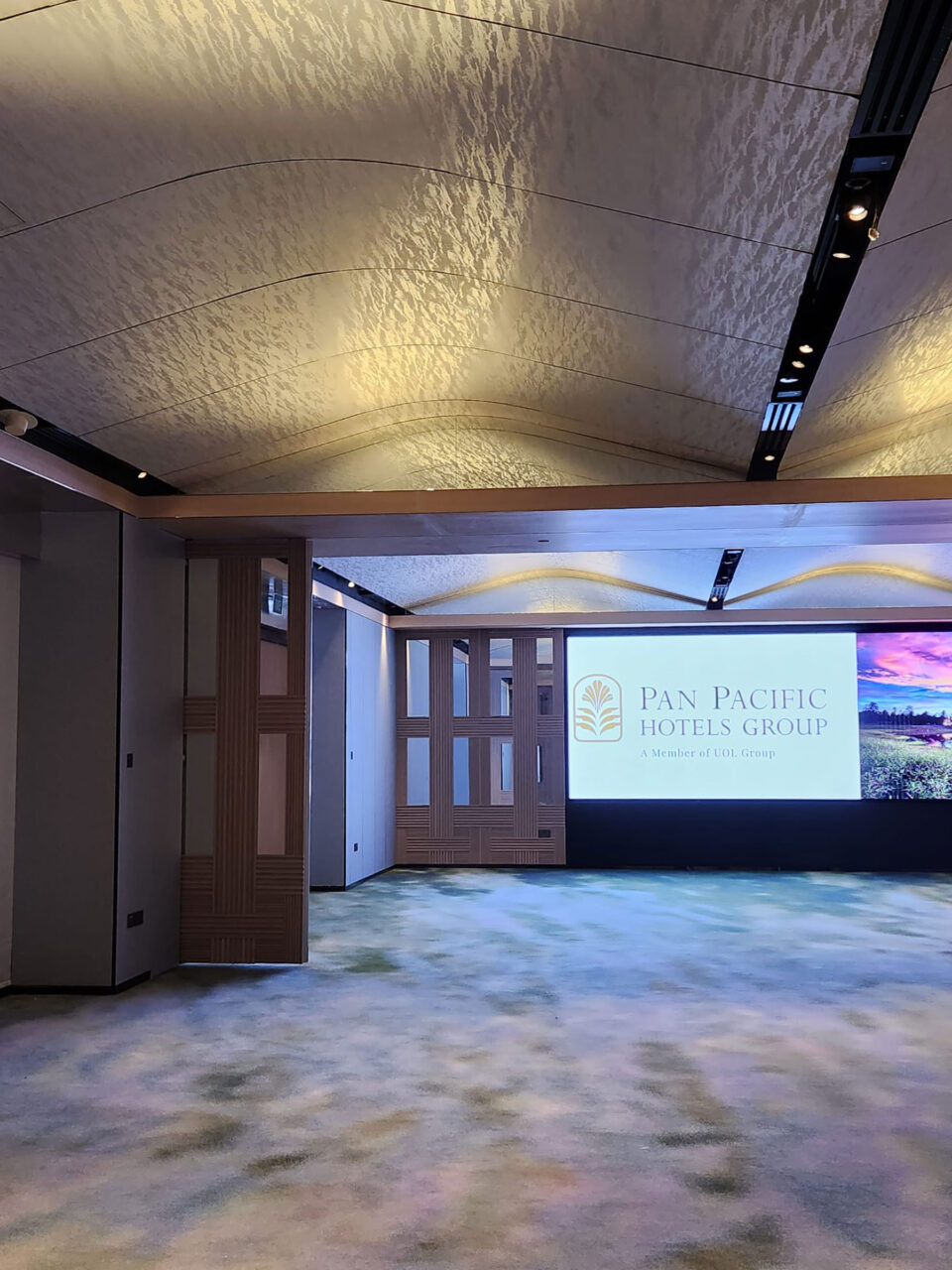 Ein Veranstaltungssaal dessen gebogene Decke mit weiß schimmernder Tapete verkleidet wurde.