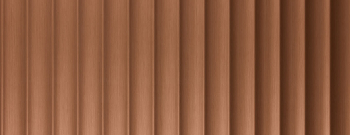 A close-up of a design panel, characterized by wide vertically running lines. The surface is brushed with a copper tone. The varying heights and depths of the structure create a particularly deep effect that impresses.