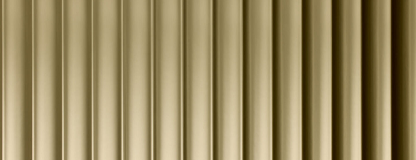 A close-up of a design panel, characterized by wide vertically running lines. The surface is reflective with a gold tone. The varying heights and depths of the structure create a particularly deep effect that fascinates.