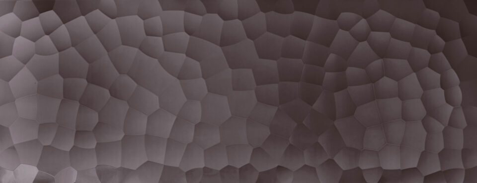 Full-plate image of a design panel whose structure is reminiscent of a hammer blow, the color is anthracite and the surface is glossy and reflective.