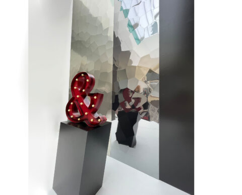 Shop window in the background silver and green metallic panels, texture like hammer blows.