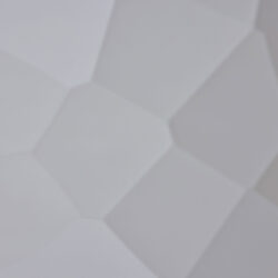 Detailaufnahme eines Designpaneels, dessen Struktur an einen Hammerschlag erinnert, die Farbe ist Silber und die Oberfläche ist glänzend spiegelnd.