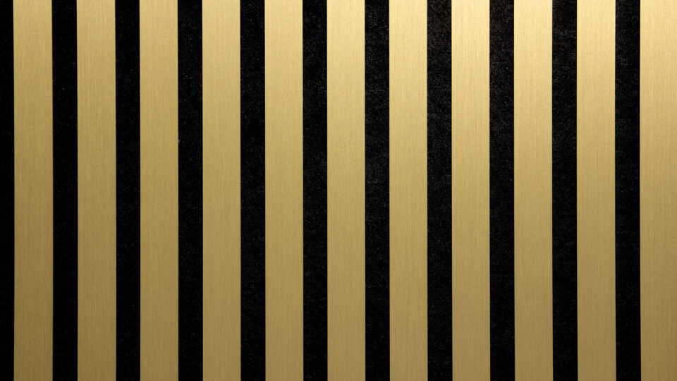 Detailed shot of a sound-absorbing acoustic panel. The surface is black and features elegant, brushed-gold stripes.