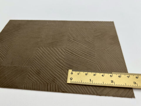 Detailed shot of a velvety mocha-colored design panel with a structured checkered pattern.