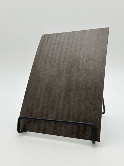 Display stand with a metallic steel-spotted design panel made of faux leather. The structure features elegant, narrow stripes that are evenly spaced in both the high and low areas.