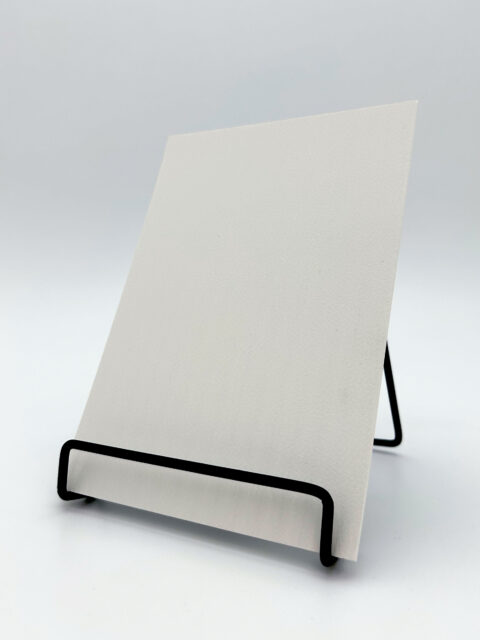 Display stand with a white design panel made of synthetic leather. The structure features elegant, narrow stripes that are evenly spaced across both the high and low edges.