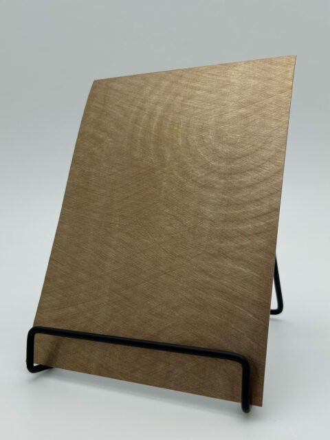 Display stand with a sandy-metallic design panel, the structure of which shows circles of different sizes that appear one after the other and contain smaller circles within themselves.