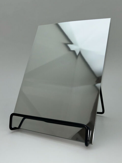 Dipslay stand with a silver reflective design panel whose structure is reminiscent of diamonds.