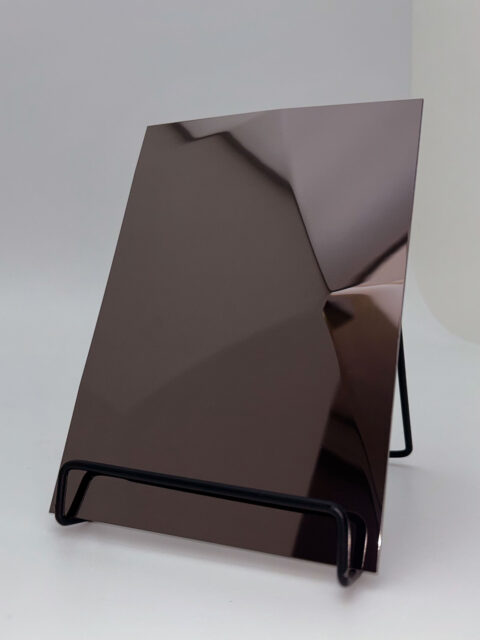 Display stand with an anthracite reflective design panel whose structure is reminiscent of hammer blows.